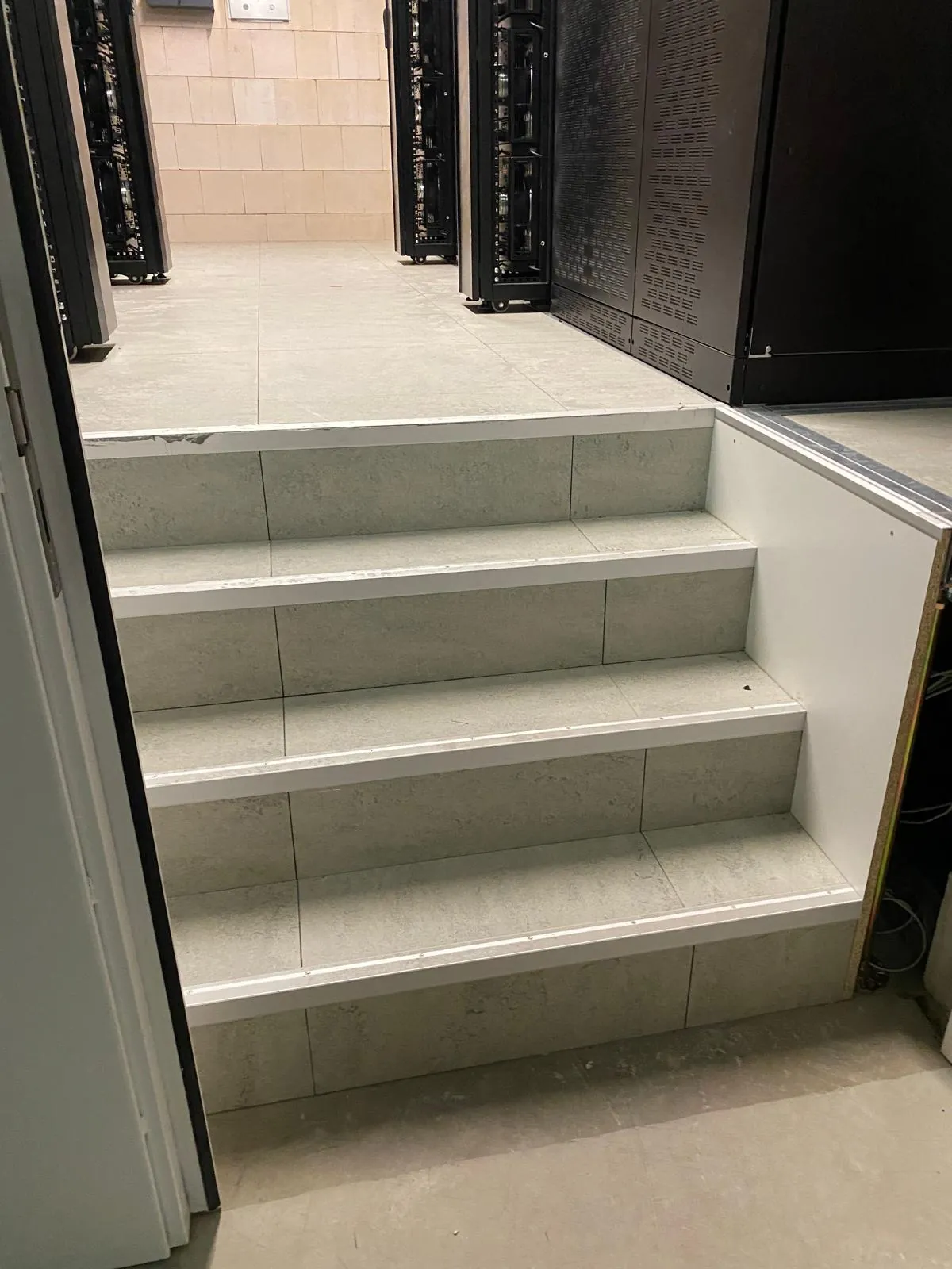 Schaltwartenboden in einem Rechenzentrum mit eingefasster Treppe zwischen Serverschränken