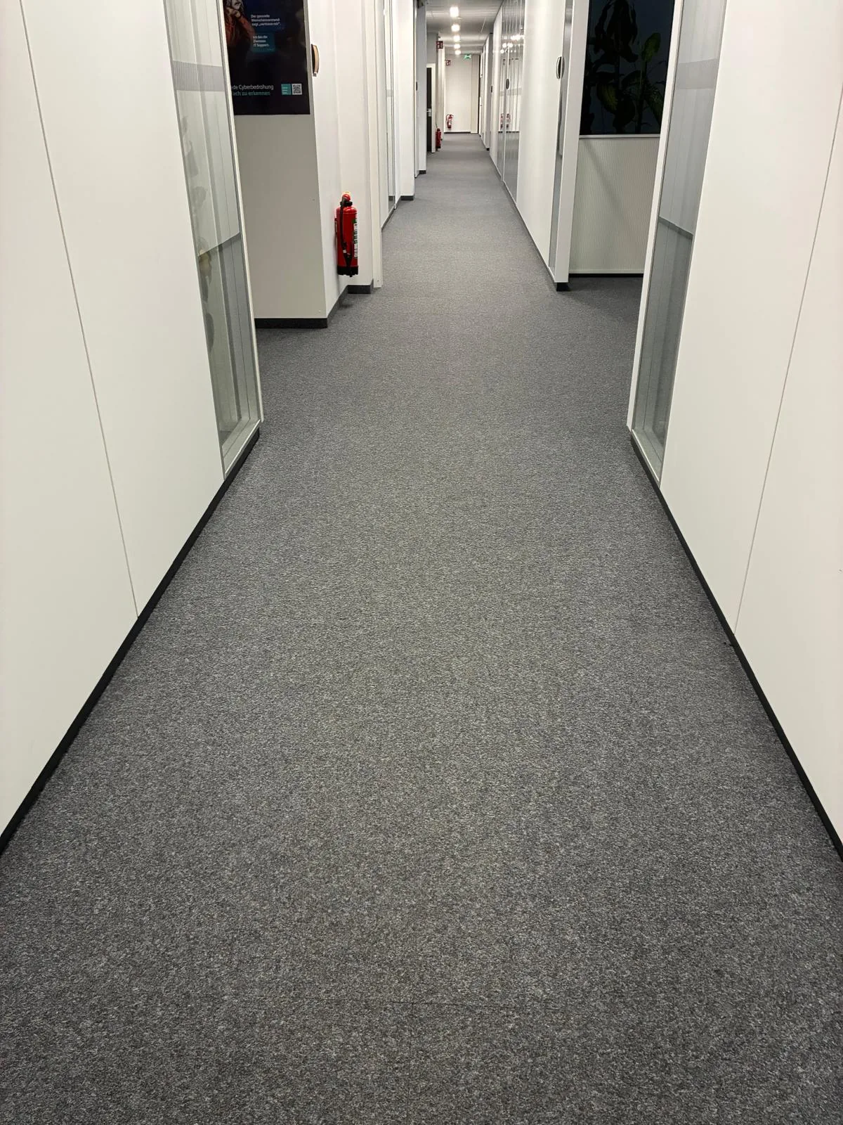 Sanierter Doppelboden mit Teppichfliesen in einem Büroflur