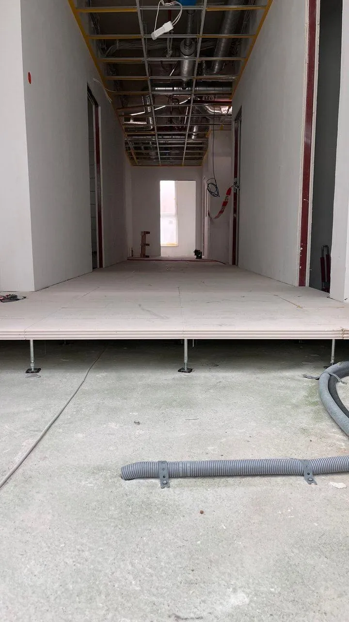 Trockenhohlraumboden im Rohbau: Trägerplatten liegen auf glatten Stützenköpfen, die Stützen stehen unter den Plattenfugen